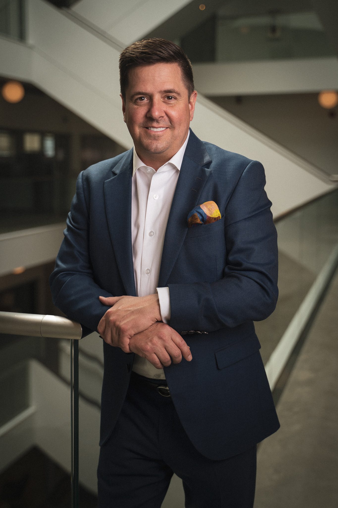 Corporate headshot of a businessman in a navy suit
